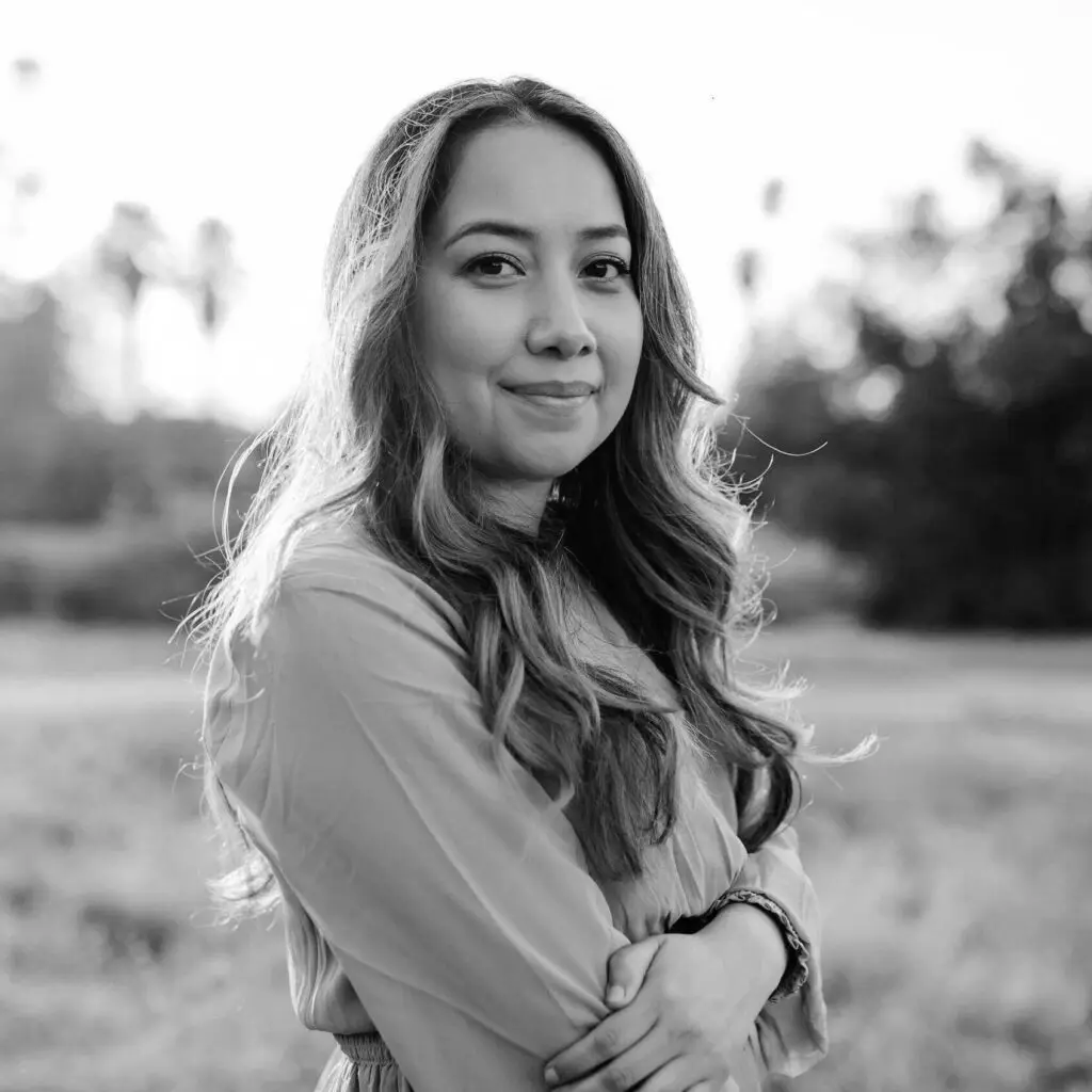 Smiling woman in nature, black and white portrait.