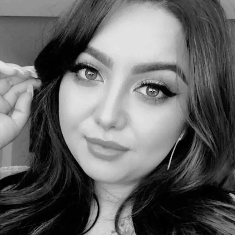 Woman with wavy hair in black and white photo.