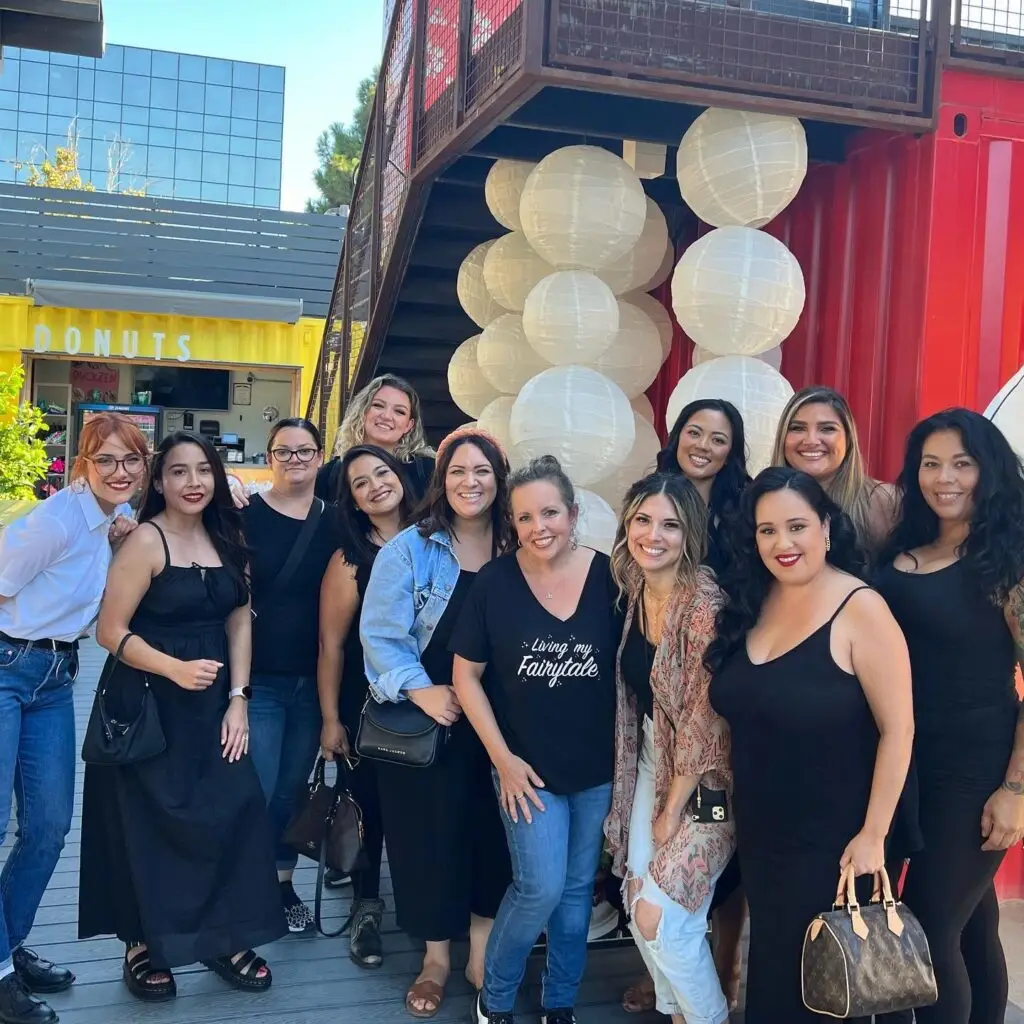 Group of women smiling outside donut shop.